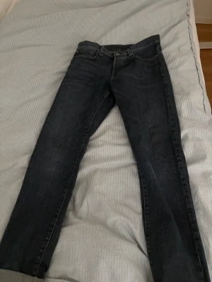 Mörkblå g-star raw byxor - Snygga mörkblå jeans från Replay med raka ben och klassisk femficksmodell. Jeansen har subtila slitningar och kontrastsömmar som ger en cool look. Tillverkade i slitstark denim med en bekväm passform. Perfekta för dig som gillar en tidlös stil.