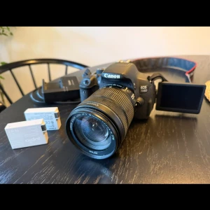 Canon EOS 700D + EF-S 18-135mm IS - Canon EOS 700D systemkamera med EF-S 18-135mm f/3.5-5.6 IS STM-objektiv. Vridbar LCD-skärm, bildstabilisering och autofokus. Inkluderar extra batterier och laddare. Mycket gott skick. Perfekt för foto och video. Pris kan diskuteras.