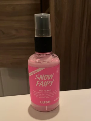 Lush Snow Fairy Hair Primer 100ml - Lush Snow Fairy Hair Primer är en rosa hårprimer i sprayflaska på 100 ml. Produkten hjälper till att skydda och återfukta håret, samtidigt som den ger en söt doft. Doftar bokstavligen godis.