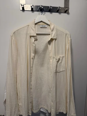 Vit linneskjorta från Weekday - Luftig och stilren vit skjorta från Weekday i linne. Skjortan har klassisk krage, knappstängning framtill och en bröstficka. Perfekt för en avslappnad och trendig look. Passar till många olika outfits.
