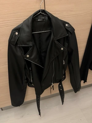 Skinn jacka från ginatricot  - Skinn jacka i läder imitation från ginatricot. Strl XS, men den har en lite oversize passform så den passar XS/S/M beroende på hur man vill att den ska sitta. Jag har oftast S/M och den är en ”normal” passform på mig. Otroligt mjukt skinn material och fina detaljer! Aldrig använd, men hann dock ta bort lappen! Nypris 800kr 