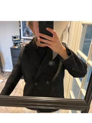 Svart kort kappa  - Säljer min fina kappa från h&m. Använd fåtal gånger och de är tjockt material. Passar S