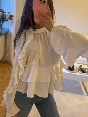 Vit volangblus med vida ärmar - Säljer denna trendiga blus med volanger från Zara