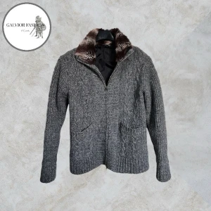 Fodrad cardigan kofta meds pälskrage  - Grå kabelstickad cardigan med diskret dragkedja och mjuk pälskrage (osäker på om det är äkta päls, men tror inte det). Funkar lika bra som en lättare jacka men också tröja .  Storlek L enligt etikett men upplevs mer som S/M. Skick 8/10 – inga defekter och väl omhändertagen.  Liknande säljs från cirka 700 kr upp till 2 500 kr | Mitt pris 699kr Hör av dig för mått!