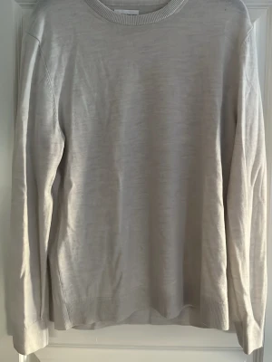 Ljusbeige merinotröja These Glory Days - Säljer en stilren ljusbeige tunn stickad tröja från These Glory Days i mjuk merinoull. Materialet är Superior Merino. Tröjan är skrynklig då den bara legat vikt och aldrig använts