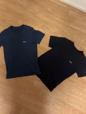 2-pack BOSS t-shirts blå  - Två stilrena t-shirts från BOSS. Klassisk passform med rund hals och korta ärmar. Diskret BOSS-logga på bröstet. Perfekta basplagg till garderoben, tillverkade i mjuk bomull för skön känsla.