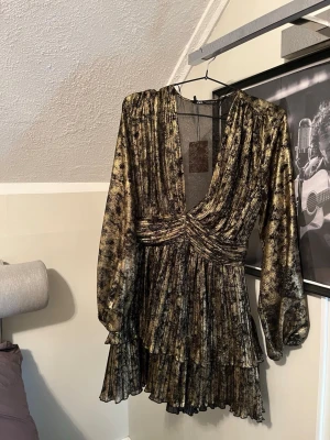 Miniklänning - Säljer denna superfina guldiga och svarta klänningen från Zara. Klänningen är i superbra skick. Har tyvärr inga bilder med klänningen på då den tyvärr är för liten för mig🥲🥲❤️Den är i storlek M men passar även en person i S tror jag!