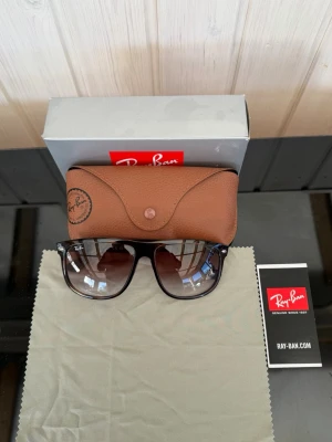 Ray-Ban boyfreind  - Ray-Ban solglasögon med svart, klassisk rektangulär båge och tonade glas. Medföljer original brunt fodral i skinn och putsduk. Perfekt för dig som vill ha en ikonisk och stilren look. Alla tillbehör ingår, köpta på synsam👍