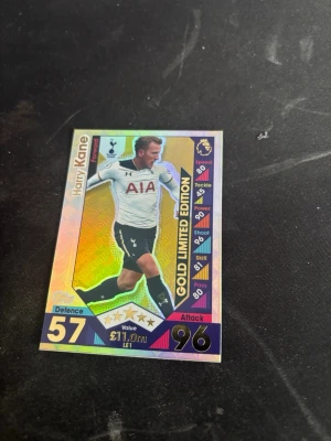 Harry Kane Match Attax Gold Limited Edition-kort  - Säljer ett Match Attax Gold Limited Edition samlarkort från Topps med Premier League-tema. Kortet visar en Tottenham Hotspur-forward och har holografisk yta med färger i guld, lila och svart. Perfekt för dig som samlar på fotbollskort eller gillar Premier League.
