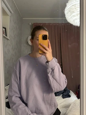 Ljuslila oversized hoodie - Säljer en ljuslila oversized hoodie med rund hals och ribbade muddar vid ärmslut och nederkant. Hoodien är enkel och stilren utan tryck eller logga, perfekt för en chill och avslappnad look. Materialet känns mjukt och bekvämt mot huden.