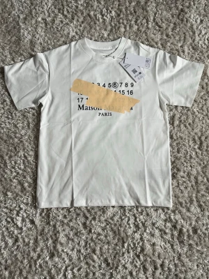 Maison Margiela vit t-shirt - Vit t-shirt från Maison Margiela Paris i mycket bra skick! Storlek S passar M. Fraktar samma dag som köp med spårbar frakt. Skriv vid frågor / funderingar. 