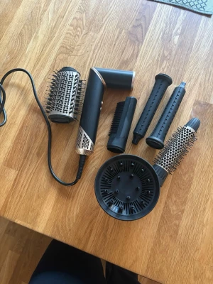 Multistyler hårverktyg med tillbehör - Säljer en svart multistyler från rusta med flera utbytbara tillbehör: rundborstar, locktillbehör, diffuser och borsthuvud. Perfekt för att skapa olika frisyrer och styling.  Har endast använt den några gånger! Nypris 1000kr, säljs för 450kr eller bud 