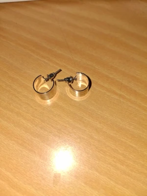 Silvriga creolörhängen i metall - Säljer ett par stilrena silvriga creolörhängen i metall. De har en klassisk rund form och stängs med plupp. Perfekta för dig som gillar minimalistisk och tidlös design.