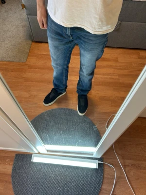 Blå raka jeans i klassisk modell - Säljer ett par blå jeans med rak passform och normal midja. Jeansen har klassisk femficksdesign och är tillverkade i denim. Perfekta för en avslappnad och stilren look. Enkla jeans att göra egna slitningar med. Nypris 900 mitt pris 449