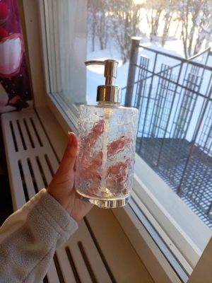Transparent tvålpump i plast - Snygg tvålpump i transparent plast med struktur och silverfärgad pump. Perfekt till badrummet eller köket för flytande tvål eller lotion. Modern design som passar in i de flesta hem.