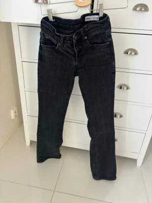 Svarta bootcut jeans från Gina Tricot - Säljer ett par svarta bootcut jeans från zara. Jeansen har klassisk femficksmodell, normal midja/ låg midja. Materialet är stretchigt denim som sitter snyggt och bekvämt. Perfekta till en trendig vardagslook.