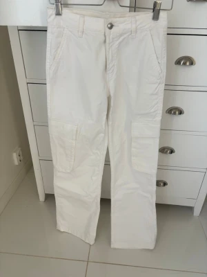 Vita cargobyxor med raka ben - Snygga vita cargobyxor med raka ben och flera praktiska fickor. Snygga för en streetwear look. Aldrig använda. Medellåg midja 