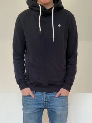 Morris Mörkblå Hoodie - Säljer en fet mörkblå hoodie från Morris i färgen mörkblå. Hoodien är i bra skick utan nåra defekter och sitter är i strl M men sitter i strl S. Hör gärna av er vid frågor elr funderingar!!