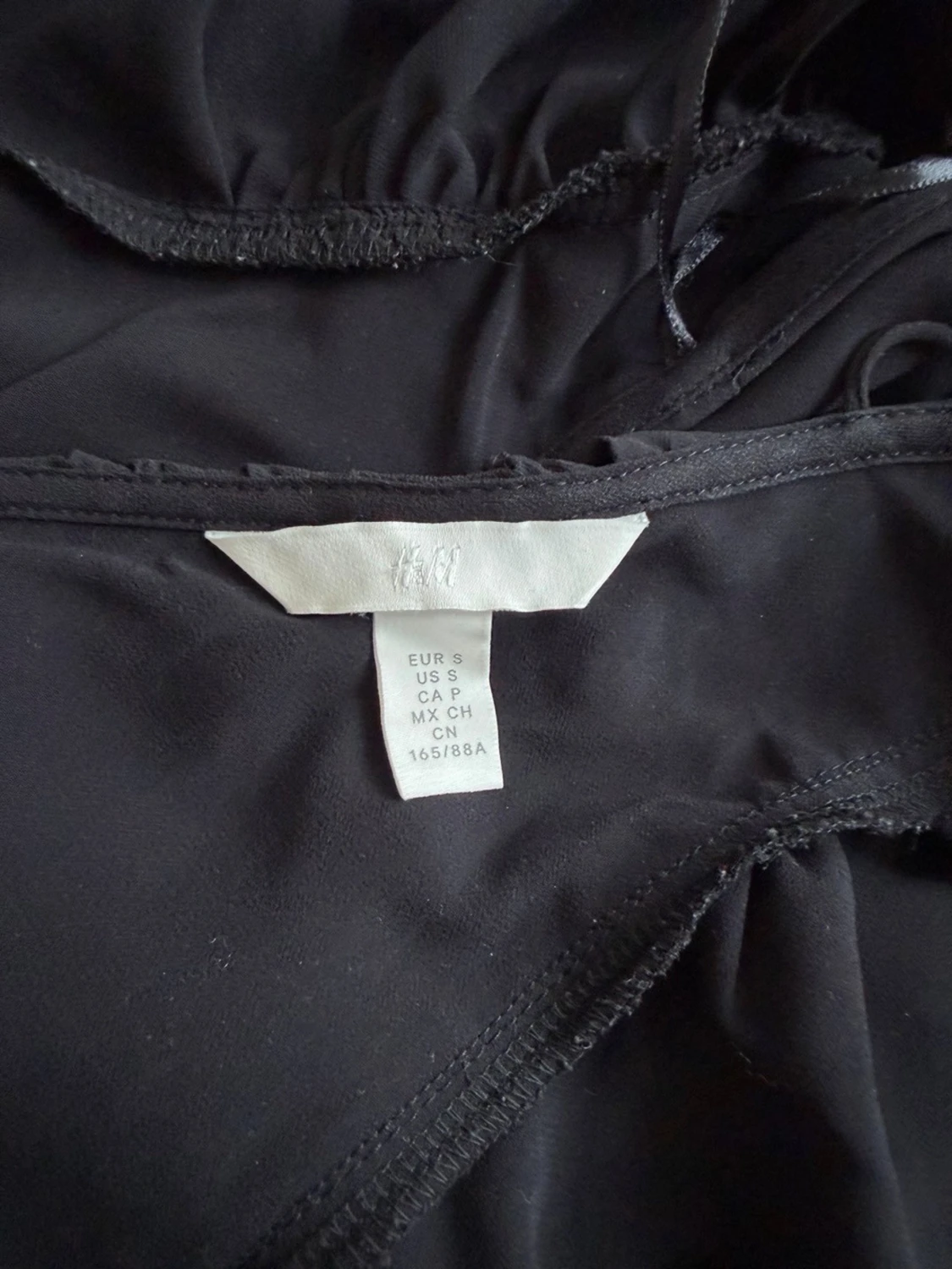 Svart v-ringad blus med volang - 2