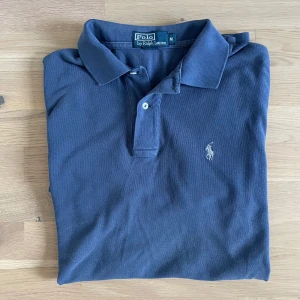 Marinblå pikétröja från Ralph Lauren - Säljer en schyst piké från Ralph lauren. Den är i använt skick men har inga större defekter. Den är i storlek M men sitter som L.   Pris 299 Skick 8,5/10 Storlek M/L  Hör av er vid frågor eller funderingar!
