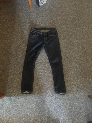 Mörkblå Nudie jeans - Säljer ett par grim Tim nudie jeans i ny-skick. Jeansen är knappt använda och passformen är slim/straight. Man kan kolla nudies egna guide om man undrar mer. Pris är diskuterbart
