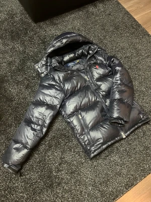 Ralph lauren jacka - Säljer en riktigt snygg Ralph Lauren glossy jacka för ett väldigt bra pris som är 3499. Jackan har inga stora defekter alls förutom väldigt få trådar som sticker ut om du kollar riktigt noggrant men förstör inte utseendet. Skriv gärna ifall ni har frågor om jackan! MVH-Marko