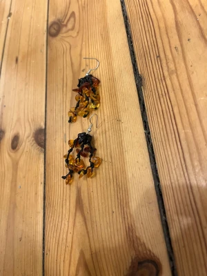 Bärnstensörhängen - Örhängen gjorda av äkta bärnstenar knutna i svarta snören. 