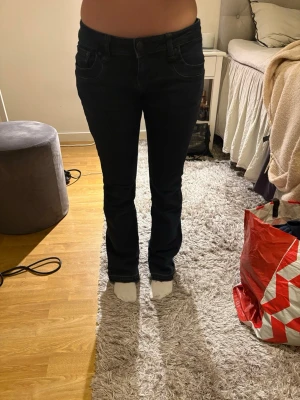Mörkblå bootcut jeans från LTB - Snygga mörkblå bootcut jeans från LTB med klassisk femficksdesign och normal midja. Jeansen har en lätt utsvängd passform nertill och är tillverkade i stretchigt denimtyg för extra komfort. Passar mig bra som har 35 cm i midja, och 85 i innerbens längd💖
