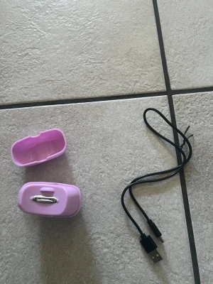 Laddningsbar elektrisk nagelklippare  - Elektrisk nagelklippare i rosa plast med tillhörande skyddsfodral och USB-laddningskabel. Smidig och kompakt design som gör den enkel att ta med i väskan. 
