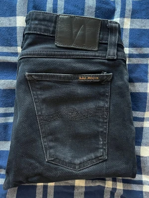 Nudie jeans  - Nudie jeans Skinny Lin. Jeansen är uppsydda så passar nog mer som L28 än L30 men utgå ifrån måtten. Jeansen har förtunnat tyg i grenen, övrigt i bra skick. JAG SKICKAR EJ FLER BILDER PÅ JEANSEN! för storleksguide hänvisar jag till måtten och för bättre inblick i passformen rekommenderar jag att googla på modellnamnet. kom ej med bud om du ej köper efter:) 1,112