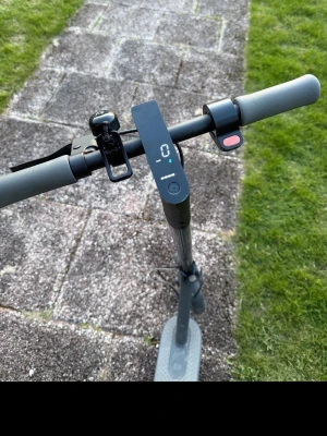 Xiaomi elscooter med display - Elektrisk sparkcykel från Xiaomi i grått med digital display, ringklocka och bred fotplatta. Utrustad med handtag i skumgummi och tydlig LED-skärm som visar hastighet och batterinivå. Perfekt för smidig transport i stan.