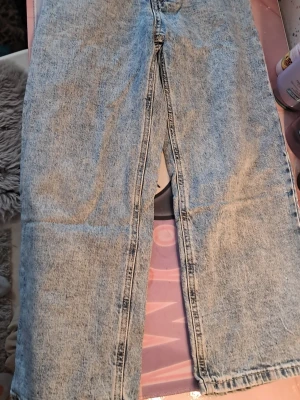 Utsvängda jeans - Säljer ett par ljusblå utsvängda jeans med rak passform. Perfekta för en avslappnad och trendig look.