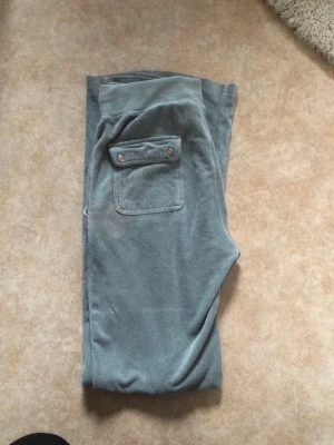 Gröna juicy couture  - Säljer dessa gröna juicy couture byxorna, de är köpta på Vinted men jag har knappt använt dem. De har två fläckar och knapparna är lite rostiga men de fungerar fortfarande dunder att ha hemma! Se bilder för att se dess skavanker. De är i handuksmaterial, skriv om ni har frågor eller om ni vill ha mått!💕
