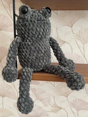Handgjord virkad groda 26cm - Handgjord virkad groda i mjukt chenillegarn, ca 26 cm från huvud till fot. Väldigt mjuk och gosig med långa armar och ben. Passar fint som dekoration eller present.