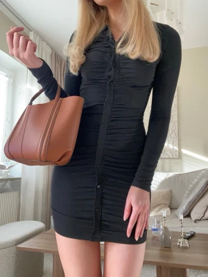 Superfin figursydd klänning med knappar framtill  - Säljer denna supersnygga svarta klänningen med knappar framtill. Perfekt både till vardags och fest beroende på hur du stylar den🤍 Storlek S