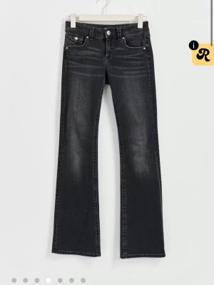 svarta bootcut jeans från Gina tricot young - snygga svarta bootcut jeans från Gina tricot young med låg midja och slitningar framtill. Jeansen har fem fickor, silverfärgade knappar och detaljerade sömmar.
