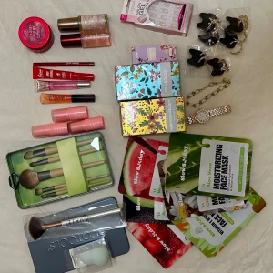 Stort kit med smink, masker och accessoarer - Helt nytt och oanvänt!! Ett komplett skönhetspaket med sminkborstar, 4 läpprodukter i rosa och röda nyanser, 3 blushsticks, 6 ansiktsmasker, 3 parfymer, bodymist , samt accessoarer som klocka och örhängen.