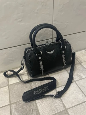 Zadig väska - PRISET ÄR INTE FAST!!😊Superfin populär väska från Zadig voltaire i mycket fint skick. Min tjej har använt den i några månader och jag hjälper nu henne att sälja den. Väskan är i mycket välbehållet skick utan defekter. Nypris är runt 5000kr. Säljes för endast 2300kr! Skickar snabbt!