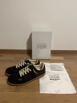 Svarta masion margelia  - Säljer ett par svarta mason margelia skor I storlek 44. Helt nya med tillbehör det som syns i bilden och fraktas samma dag!