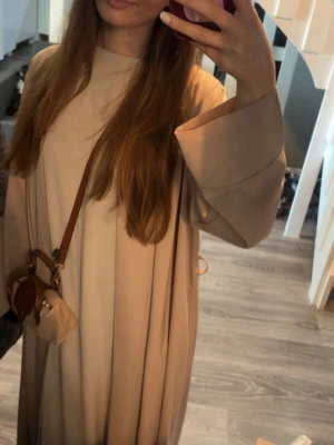 Beige open abaya - Beige open abaya, perfekt på mig som är 168 ungefär. Den har några små defekter men syns bara på nära håll