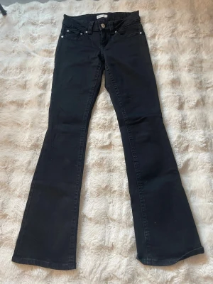 Svarta bootcut jeans med fickor - Snygga svarta bootcut jeans med klassisk femficksdesign och silverfärgade knappar på bakfickorna.säljer då dom inte passar. andvända typ tre gånger. 