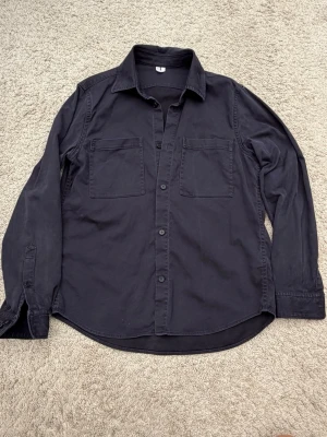 Mörkblå overshirt från Arket - Säljer en somrig overshirt från Arket i marinblå färg. Använt men bra skick. Storlek 48 som motsvarar medium.