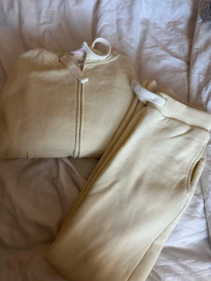 Gul  hoodie med dragkedja och huva/byxor - Gult mjukis sett från Gina, byxor i xss och tröja S