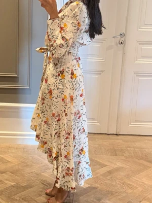 Zimmermann  - Zimmermann klänning i linne, klänningen är wrap i modellen med blommigt mönster och volangdetaljer. Klänningen har långärmade ärmar och ett knytband i midjan som ger en snygg passform.                                                     Klänningen är en ordinarie storlek 2 men jag har varit hos skräddaren och sytt in den något så skulle säga att det är en storlek 1, vilket motsvarar en storlek 36. Klänningen är buren vid 1 tillfälle och är i ny skick. Nypris 950 euro 