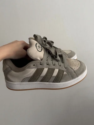 Adidas campus - Sneakers från Adidas i beige och olivgrönt. Ovandelen är i mocka och textil.