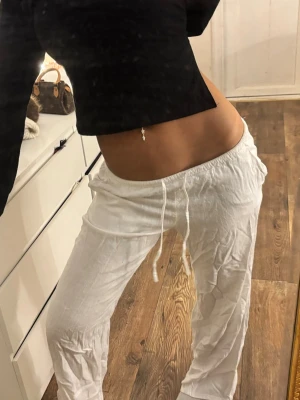 Vita linnebyxor  - Snygga vita linnebyxor med avslappnad passform och dragsko i midjan. Perfekta för en chill och stilren look. Lätta och luftiga, passar perfekt till sommaren. Inga synliga loggor eller märken.