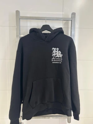 Svart hoodie från Hoodrich UK - Svart hoodie från Hoodrich UK med stor huva och magficka. Tryck i vitt på bröstet och stort grafiskt tryck på ryggen med text och coola detaljer. Tillverkad i mjukt bomullsmaterial, perfekt för en streetwear-look. Dm för frågor osv. Går bra att skicka prisförslag!