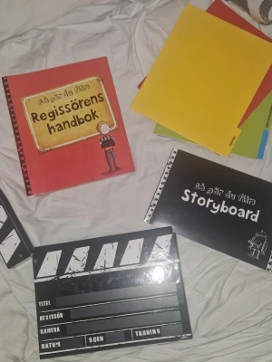 Så gör du film-kit med handbok - Ett komplett filmkit för att lära sej göra film. Paketet innehåller en "Regissörens handbok", en "Storyboard"-bok och 4st mappar fyllda med olika rekvisita samt en klassisk filmklappa. Materialet är utformat för att täcka grunderna i filmproduktion, inklusive planering av scener och tagningar. Helt nytt!