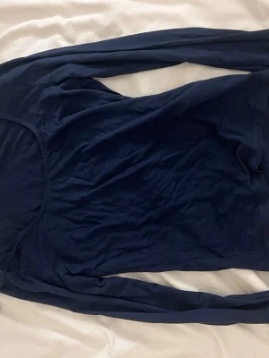 Mörkblå långärmad topp - En basic mörkblå långärmad topp med rund halsringning. Toppen har en tajt passform. Säljer två likadana tröjor i vit och svart ifall intresserad🤗!!Om du köper välj gärna att hämta upp på upphämtningsställe då det blir enklare för mig att posta på det viset!!