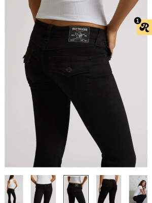 Svarta bootcut jeans True Religion - Snygga svarta bootcut jeans från True Religion med klassiska fickor och logotyp på bakfickan. Jeansen har en figurnära passform upptill och utsvängda ben. Materialet är stretchigt denim som ger en bekväm känsla och cool look.